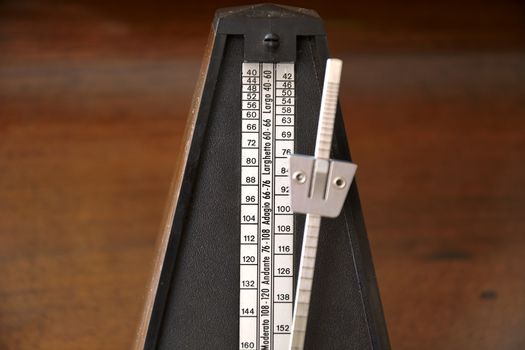 Close up of a vintage metronome with swinging pendulum