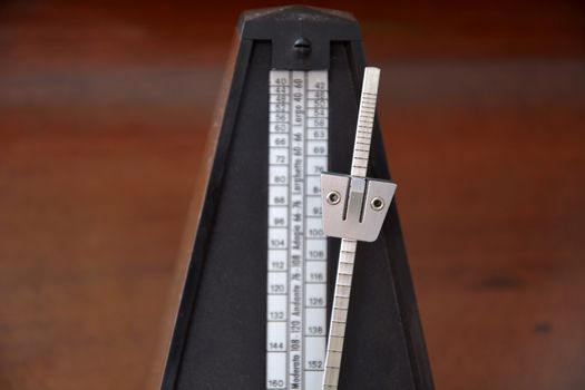 Close up of a vintage metronome with swinging pendulum