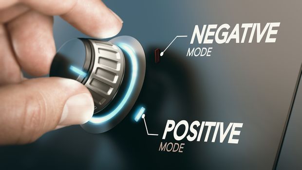 Hand turning a knob to switch from negative to positive mindset. Psychology concept. Composite image between a photography and a 3D background.