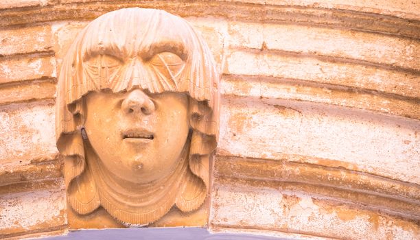 Gothic detail. Young woman portrait at the entrance of a 200 years old building in Ciutadella town, Menorca (Spain)