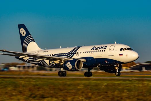 The plane takes off at dawn at high speed. Photo from the runway. Airport Khabarovsk-Novy UHHH , Russia. Airbus A319-111.