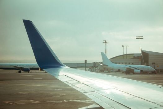 Commercial airplane wing and other commercial airplanes near terminal 3 at Ben Gurion international airport.
