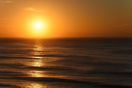 Vibrant orange clear sky sunrise ocean horizon, Mossel Bay, South Africa