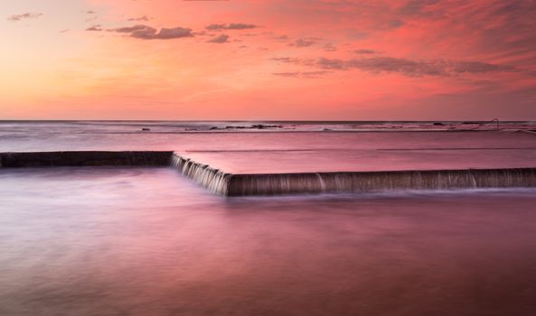 Such pretty skies overhead reflect in rushing waters of the pool overflowing onto rocks, unseen.