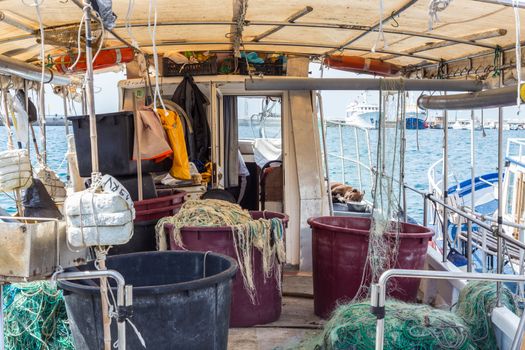 The fishing boat's interior, the right side of the boat, the fishing tools, the fishing industry, the rusting cabin.