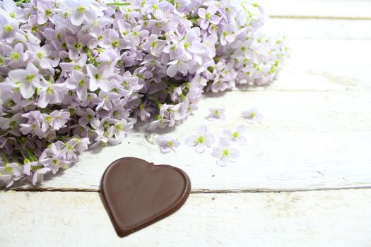 The picture shows cuckoo flowers with chocolate hearts.