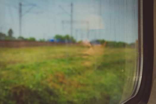 Mysterious woman face with black sunglasses reflected in the window of a traveling train. Nostalgic moment concept.