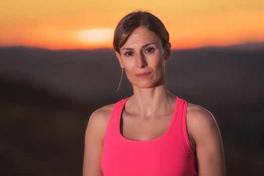 Young beautiful woman portrait in sport clothes at sunset