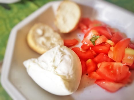 Fresh Italian caprese salad with mozzarella cheese, tomatoes and bread. Summer food