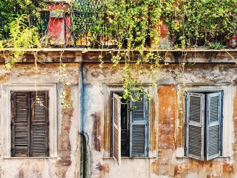 Three ancient windows with closed shutters. European architecture