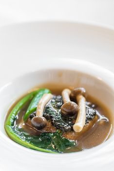 baked homemade tofu with kale and mushroom in gravy sauce