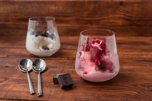 Sweet desert with ice cream, chocolate and berries on wooden background