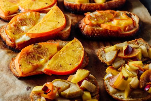 Baked Bruschettas with Fresh Fruits on Parchment Paper