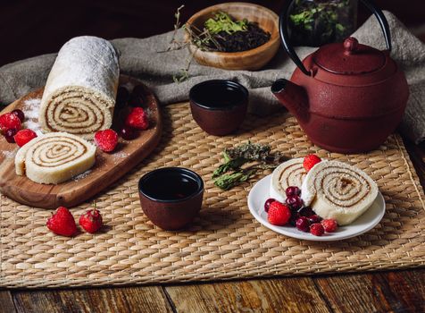 Two Slices of Biscuit Roll with Berries and Two Cup of Tea.