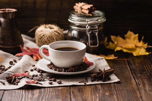 Autumn Leaves with Cup of Coffee. Ingredients, Spices and Some Kitchenware on dark wooden surface.