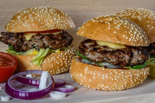 Three fresh burger lay on the board. Homemade fast food more tasty and healthy.