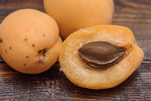 half of apricot with pip on dark wooden background