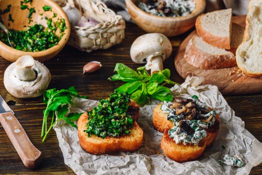 Italian Snack. Two Bruschettas with Greens and Mushrooms on Paper with Ingredients.