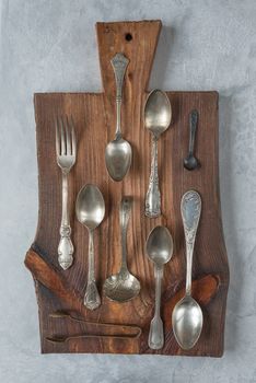 Various vintage tableware on an old wooden cutting board. Vertical image