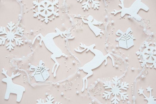 Christmas background composed of white christmas decoration: snowflakes, deers, flying angel and gift boxes on pink background. Christmas wallpaper. Flat lay composition for websites, social media, business owners, magazines,  bloggers, artists etc.