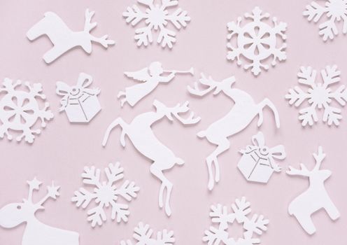 Christmas background composed of white christmas decoration: snowflakes, deers, flying angel and gift boxes on pink background. Christmas wallpaper. Flat lay composition for websites, social media, business owners, magazines,  bloggers, artists etc.