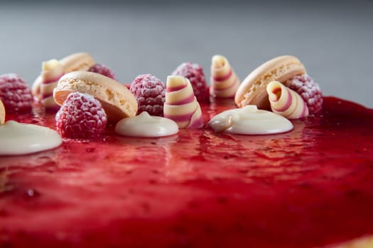 Decoration with raspberries, chocolates and biscuits on a cake