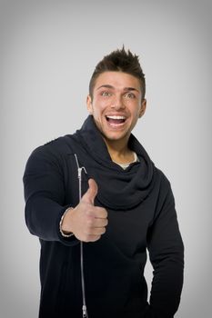 Attractive happy young man smiling, doing thumb up sign with his hand, isolated on white
