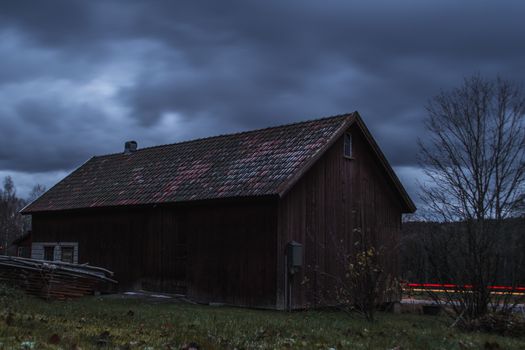 Long exposure of a old barn by a road with car trails