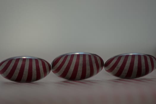 Three spoons composed to reflect red vertical lines