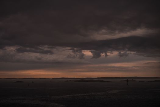 Stormy powerful clouds by the ocean during sunset