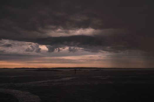 Stormy powerful clouds by the ocean during sunset