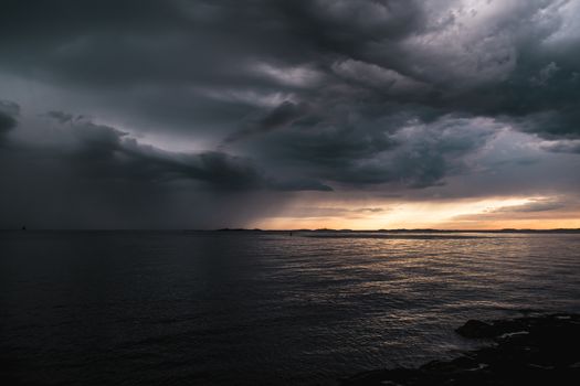 Stormy powerful clouds by the ocean during sunset