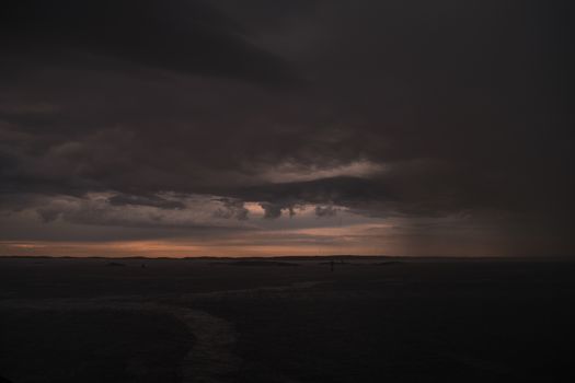 Stormy powerful clouds by the ocean during sunset