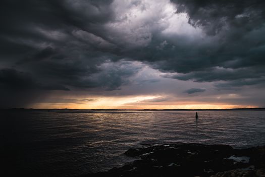 Stormy powerful clouds by the ocean during sunset