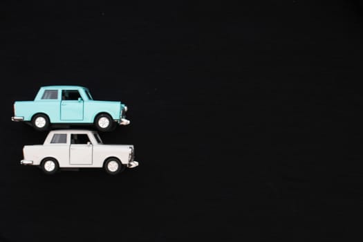 Flat lay of a white and blue toy car with a black background