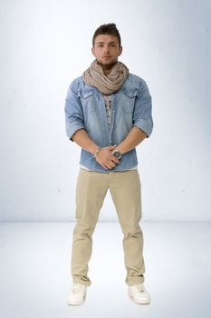 Handsome young man standing with denim shirt and scarf, full length body shot