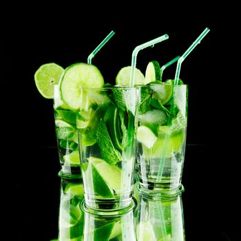 Mojito cocktails with lime and mint on black background 