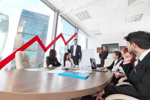 Business people discuss red arrow of income growth at meeting