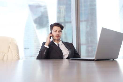 Busy businessman in office working on his laptop