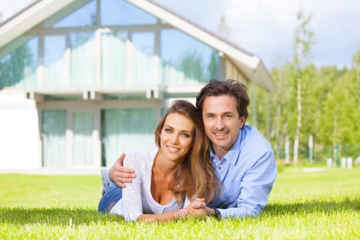 Happy smiling couple laying down in their home garden