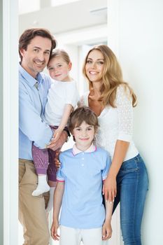 Portrait of happy smiling family with little children in doorway