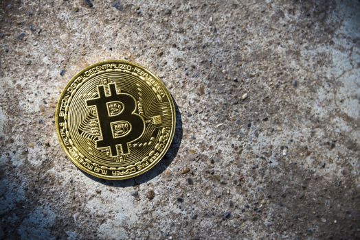 Gold coin Bitcoin on the stone background.