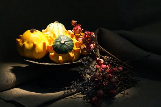 Vintage still life with few small pumpkins in old metal bowl