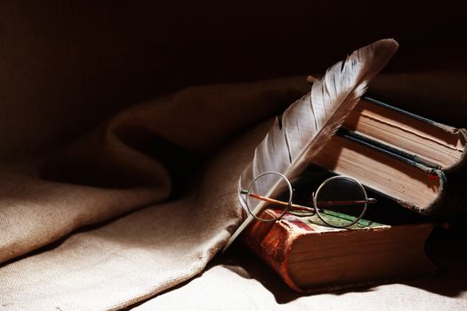 Vintage still life with old books and spectacles on canvas background