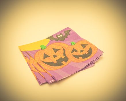 Top view stack of friendly Halloween napkins isolated on white background. Festive party tissue piles display pumpkins, bats, jack-o-lantern