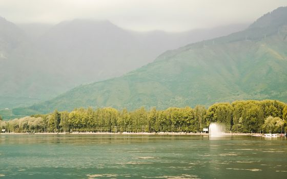 Panoramic Landscape scenery heavenly pristine beauty of world famous Dal Lake, Srinagar, Jammu and Kashmir, India. The Great Himalayas range at a distance. Image from beach side in romantic sunset.