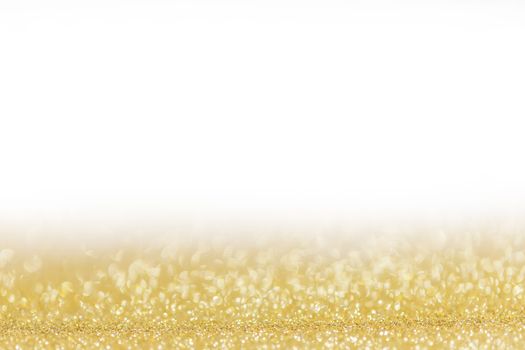 Golden festive glitter background with defocused lights , white copy space