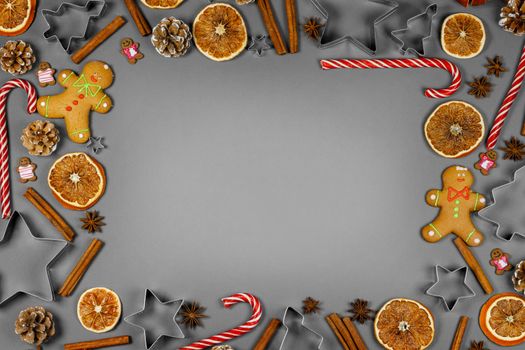 Christmas food frame. Gingerbread cookies, spices and decorations on gray background with copy space