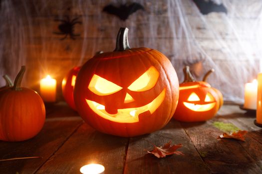 Jack O Lantern Halloween pumpkin, bats on web and burning candles