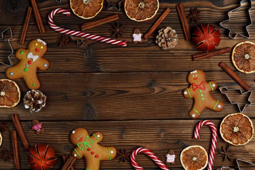 Christmas food frame. Gingerbread cookies, spices and decorations on wooden background with copy space